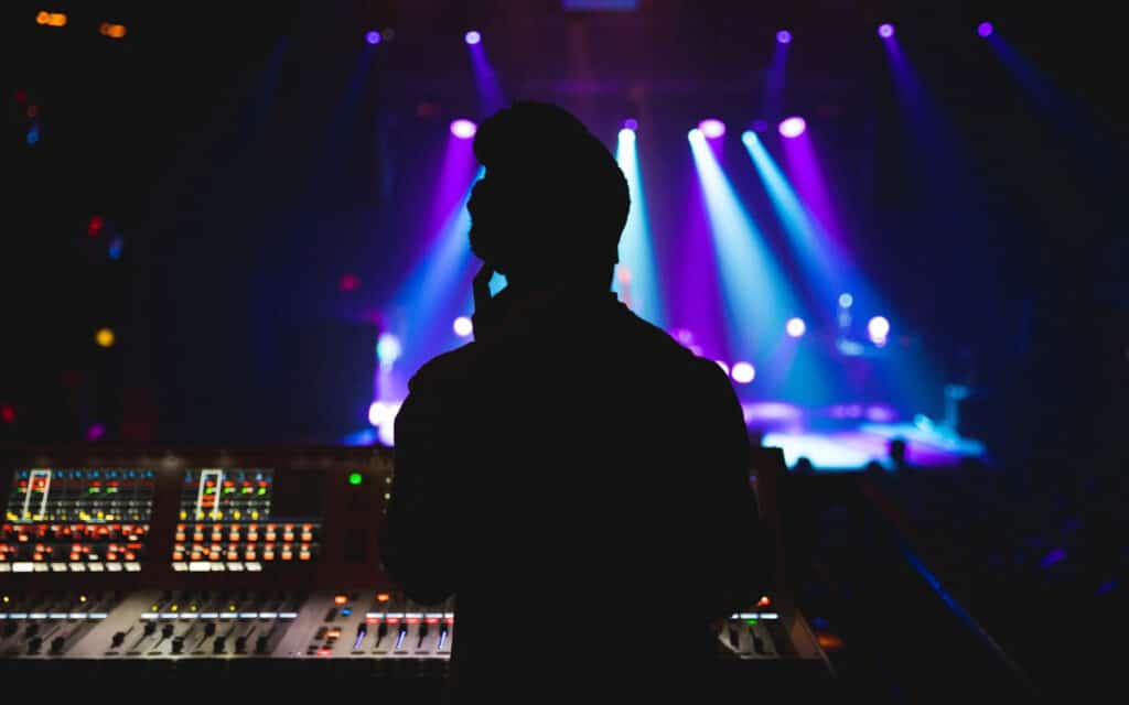 Man standing at soundboard for a concert