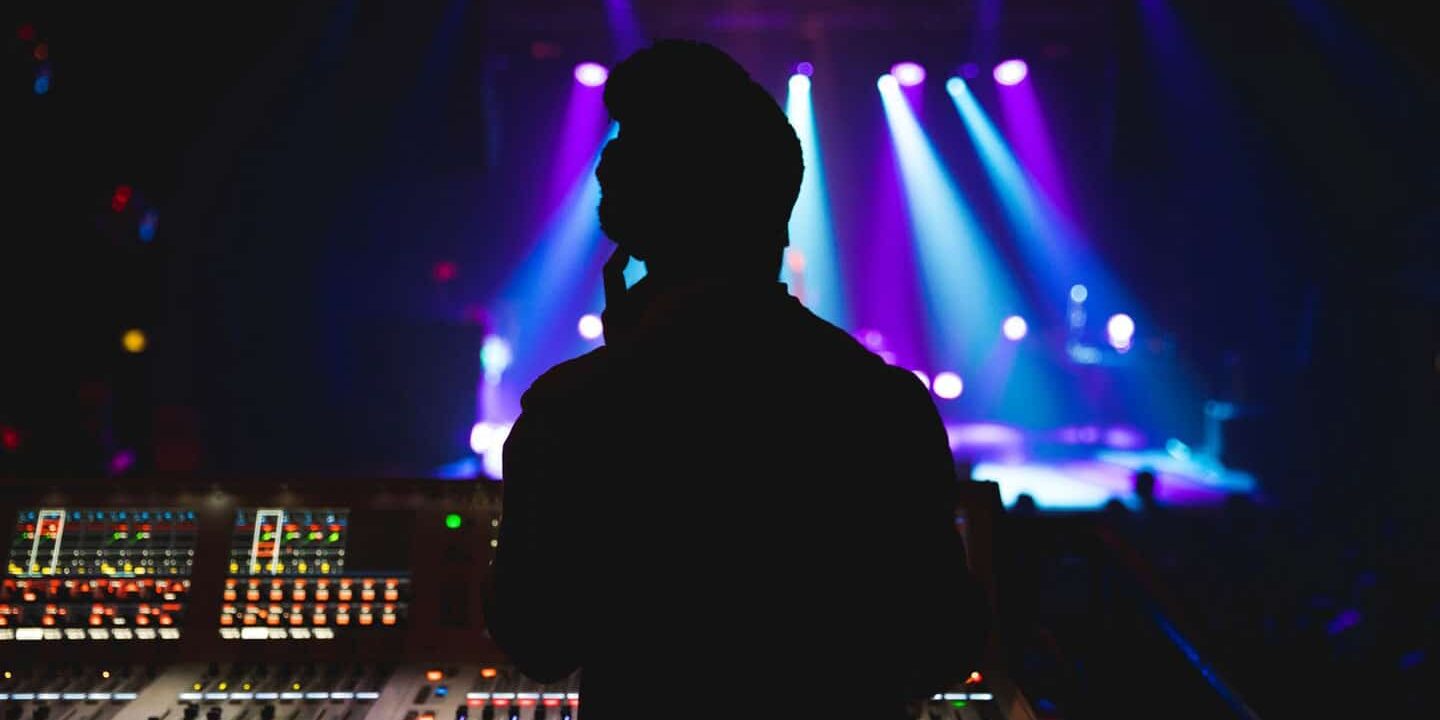 Man standing at soundboard for a concert